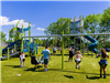 Families enjoying swings and slides at new playground