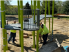 Workers installing bright green playground posts