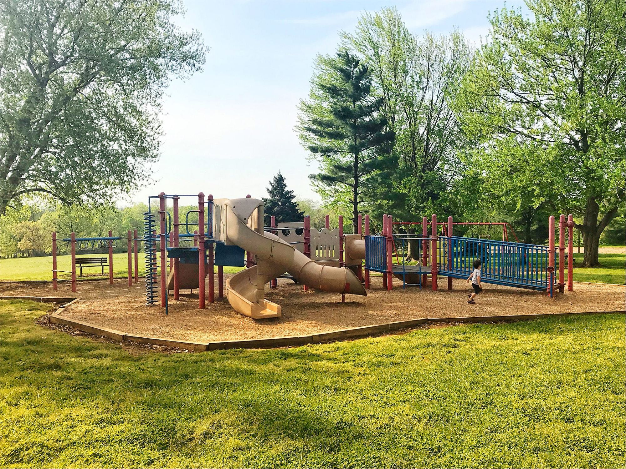 Child playing at the old playground with slides and climbing structures