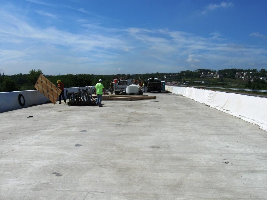 After completing the new deck, the bridge's parapets were poured and are shown being water cured